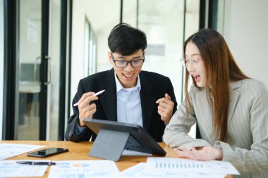 İki işadamı mali raporları birlikte inceledikten sonra başarılı sonuçları kutluyor