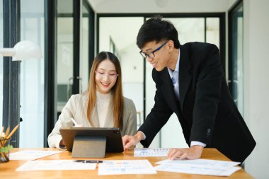 İki profesyonel mali tabloları gözden geçirir ve takım toplantısında yatırım stratejisini tartışır.