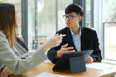 İki profesyonel mali tabloları gözden geçirir ve takım toplantısında yatırım stratejisini tartışır.