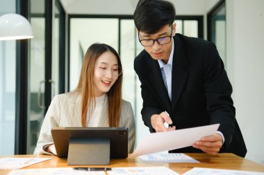 İki profesyonel mali tabloları gözden geçirir ve takım toplantısında yatırım stratejisini tartışır.