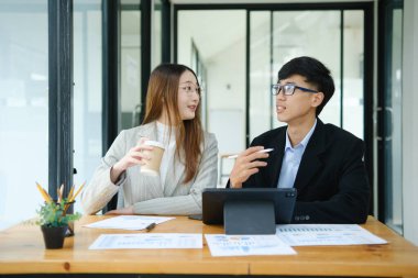 İki profesyonel mali tabloları gözden geçirir ve takım toplantısında yatırım stratejisini tartışır.