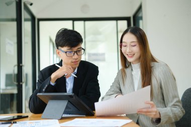 İki profesyonel mali tabloları gözden geçirir ve takım toplantısında yatırım stratejisini tartışır.