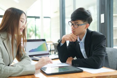 İki profesyonel mali tabloları gözden geçirir ve takım toplantısında yatırım stratejisini tartışır.