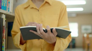 Sayfa kitabını çeviren erkek ellerinin yakın çekimi. Kitap okuyan kadın..