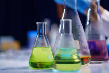 Laboratuvar deneyleri, ölçümler ve profesyonel bir laboratuvarda reaksiyonların gözlemlenmesi için düzenlenmiş kimyasal çözümler içeren cam şişeler..