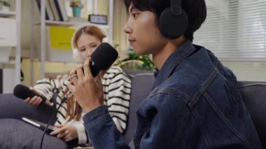 Neşeli radyo sunucusu, iş arkadaşıyla birlikte podcast 'i gösteriyor. Evdeki podcast stüdyosunda eğleniyor, konuşuyor ve kayıt yapıyor..