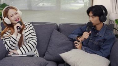 Neşeli radyo sunucusu, iş arkadaşıyla birlikte podcast 'i gösteriyor. Evdeki podcast stüdyosunda eğleniyor, konuşuyor ve kayıt yapıyor..