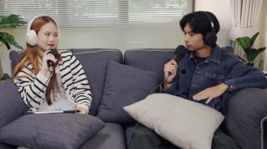 Neşeli radyo sunucusu, iş arkadaşıyla birlikte podcast 'i gösteriyor. Evdeki podcast stüdyosunda eğleniyor, konuşuyor ve kayıt yapıyor..