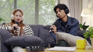 Neşeli radyo sunucusu, iş arkadaşıyla birlikte podcast 'i gösteriyor. Evdeki podcast stüdyosunda eğleniyor, konuşuyor ve kayıt yapıyor..