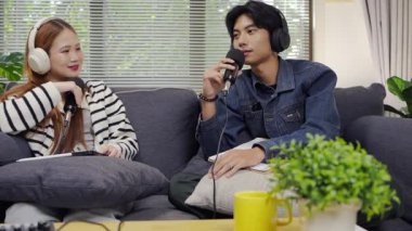 Neşeli radyo sunucusu, iş arkadaşıyla birlikte podcast 'i gösteriyor. Evdeki podcast stüdyosunda eğleniyor, konuşuyor ve kayıt yapıyor..