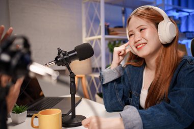 Genç adam ve kadın küçük yayın stüdyosunda mikrofon ve dizüstü bilgisayar kullanarak canlı yayın yapan radyo yayını için röportaj yapacaklar.,