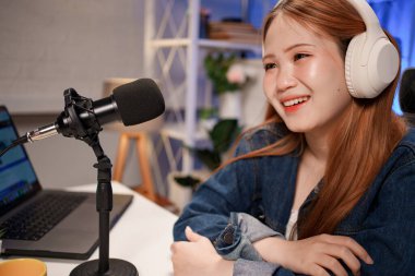 Genç adam ve kadın küçük yayın stüdyosunda mikrofon ve dizüstü bilgisayar kullanarak canlı yayın yapan radyo yayını için röportaj yapacaklar.,