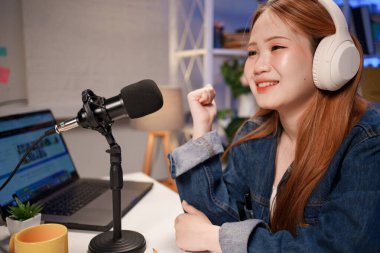 Genç adam ve kadın küçük yayın stüdyosunda mikrofon ve dizüstü bilgisayar kullanarak canlı yayın yapan radyo yayını için röportaj yapacaklar.,