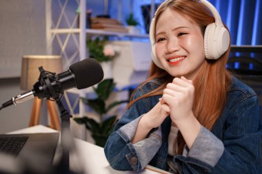 Genç adam ve kadın küçük yayın stüdyosunda mikrofon ve dizüstü bilgisayar kullanarak canlı yayın yapan radyo yayını için röportaj yapacaklar.,