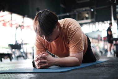 Beden eğitiminde paspas, çekirdek gücü, denge ve dayanıklılık üzerinde fazla kilolu adam tahtası egzersizi. Fitness eğitimi, kilo kaybı ve sağlıklı yaşam tarzı kavramı.