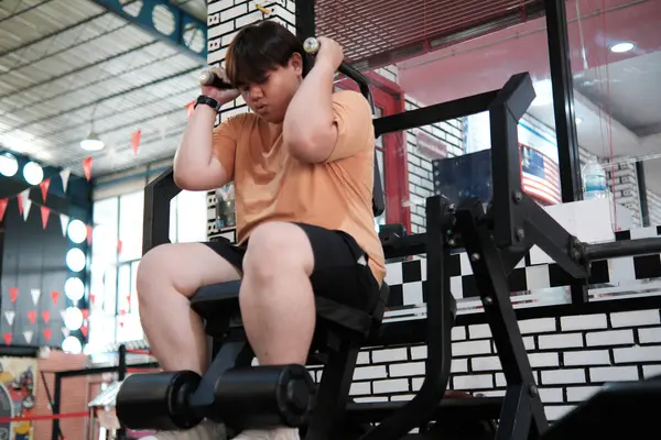 Kararlı artı boy erkek fitness yolculuğu, karın kası çatırdatma makinesi üzerinde acı verici bir çaba gösteriyor..