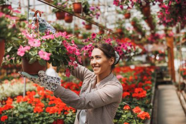 Çiçek bahçesinde çiçeklerle çalışan genç bir kadın. Kadın girişimci.