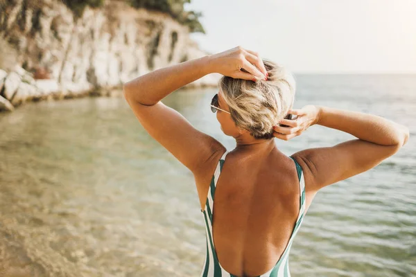 Tylny Widok Atrakcyjnej Kobiety Średnim Wieku Jest Korzystających Pozowanie Plaży — Zdjęcie stockowe
