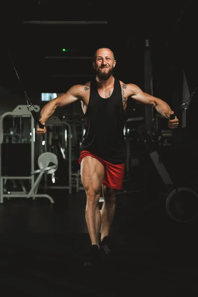 ジムで胸の筋肉のためのハードトレーニングをしている若い筋肉のボディビルダーの男 — ストック写真