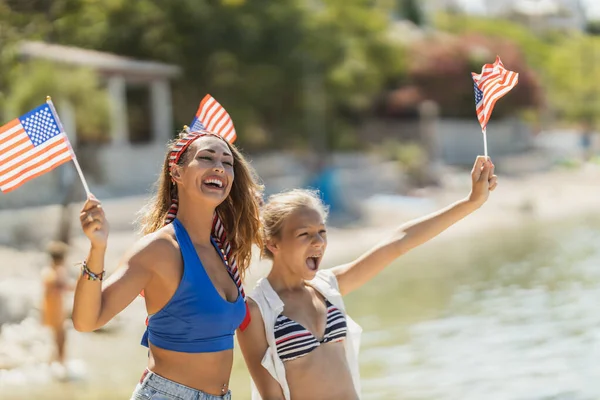 Fröhliches Teenie Mädchen Und Ihre Junge Mutter Mit Nationalflagge Strand — Stockfoto