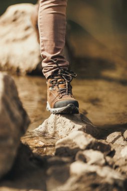Ormanı keşfederken nehirden geçen tanınmayan bir kadın yürüyüşçünün görüntüsü..