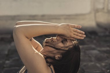 Çatıdaki terasta yoga yapan rahat genç bir kadının yakın çekimi..