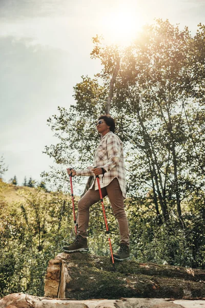 外に一人で立って自然の中でハイキングしながら森の景色を楽しむ熟女 — ストック写真