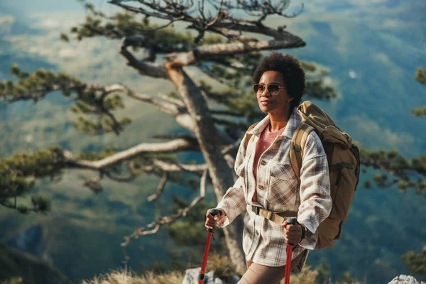 丘の上に立って山の中でハイキング中に景色を楽しむ熟女 — ストック写真