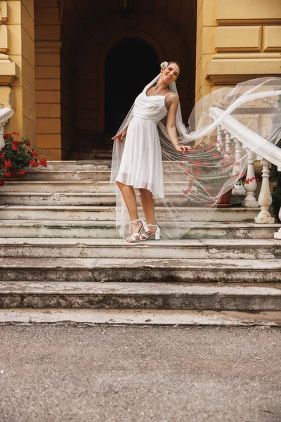 신부의 바람에 나부끼는 가운데아름다운 계단에서 재미있게 — 스톡 사진