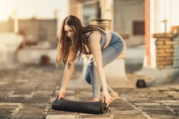 Mujer Relajada Está Enrollando Esterilla Ejercicio Preparándose Para Practicar Yoga —  Fotos de Stock