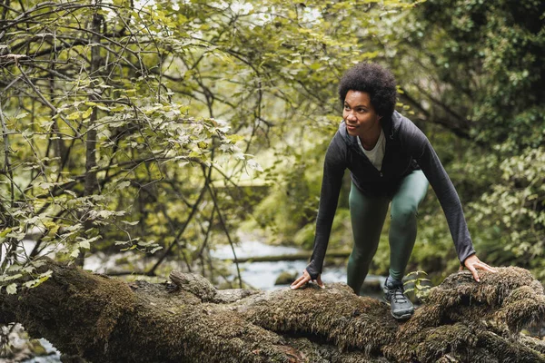 Wanita Afrika Amerika Yang Dewasa Berjalan Atas Batu Saat Menjelajah — Stok Foto
