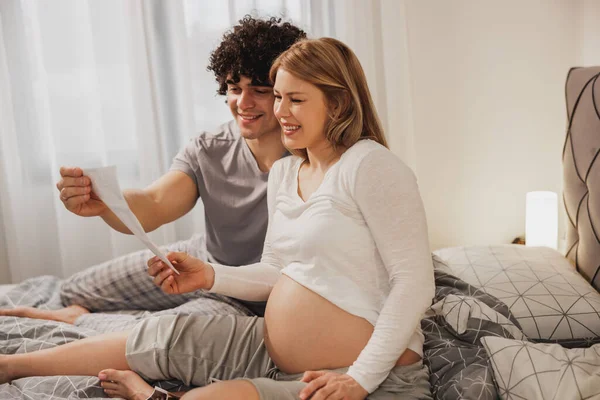 Feliz Pareja Embarazada Mirando Escaneo Médico Bebé Mientras Relaja Una — Foto de Stock