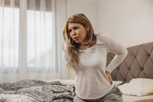 Besorgte Schwangere Atmet Und Hält Ihren Rücken Vor Schmerzen Fest — Stockfoto