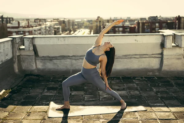 Ontspannen Jonge Vrouw Die Yoga Beoefent Een Dakterras Stadsgebouwen Achtergrond — Stockfoto