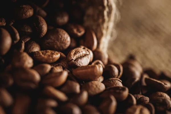 Detailní Záběr Čerstvých Pražených Kávových Zrn Roztroušených Pytle — Stock fotografie