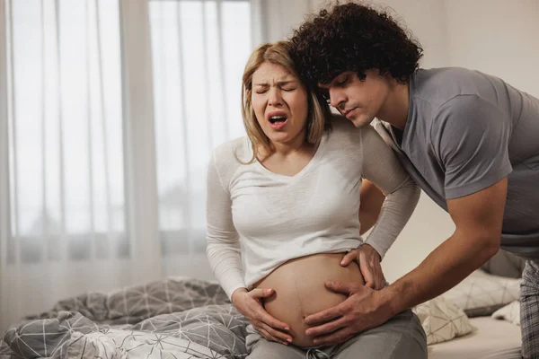 Hombre Preocupado Ayudando Esposa Embarazada Dormitorio Que Está Teniendo Una —  Fotos de Stock