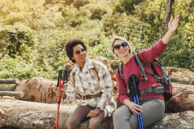 Doğada yürüyüş yaparken bir şeyi işaret eden iki melez kız arkadaş.. 