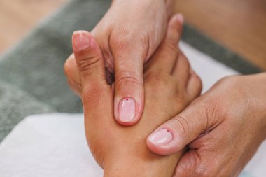 Güzellik salonunda el masajı ve manikür yaptıran tanınmayan genç bir kadının görüntüsü..