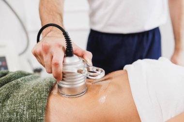 Güzellik salonunda karın yağlarını azaltmak için ultrason çektiren tanınmamış bir kadın..