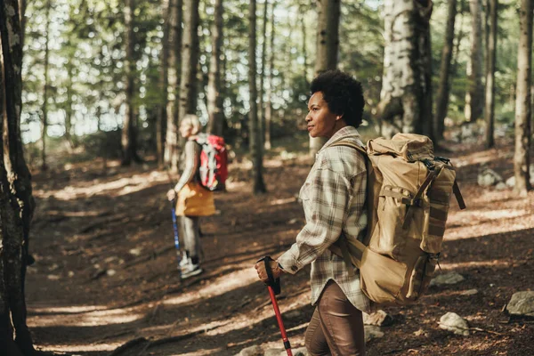 Mature black woman hiking through the mountains with her friend