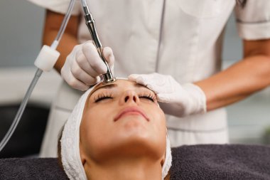 Güzeller güzeli genç bir kadının güzellik salonunda mikro cilt bakımında çekilmiş fotoğrafı..