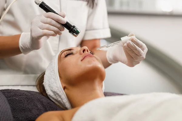 Shot of a beautiful young woman on a facial mesotherapy non needle treatment at the beauty salon.