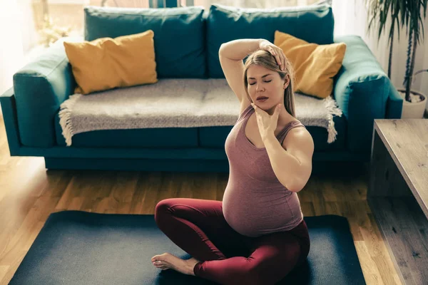 一名身穿运动服的孕妇正在客厅里伸展和锻炼瑜伽 以增进她的健康 — 图库照片