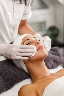 Güzellik salonunda yüz bakımı yapan güzel bir kadının fotoğrafı..