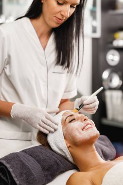 Güzeller güzeli genç bir kadının güzellik salonunda maske taktırırken fotoğrafı..