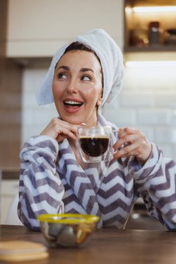 Çekici bir kadın evde sabah kahvesini içip dinleniyor..