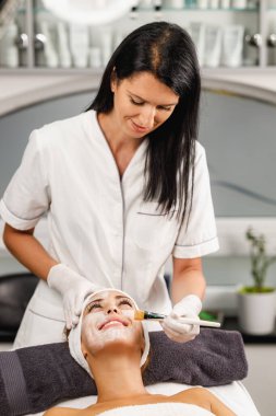 Güzeller güzeli genç bir kadının güzellik salonunda maske taktırırken fotoğrafı..