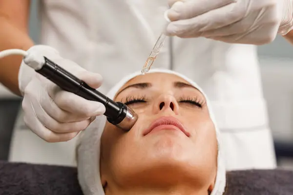 Shot of a beautiful young woman on a facial mesotherapy non needle treatment at the beauty salon.