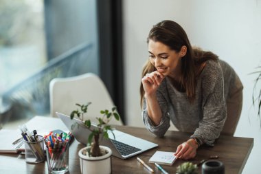 Evinde çalışan genç bir kadın..