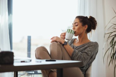 Genç bayan serbest yazar evde çalışırken kahve molası veriyor..